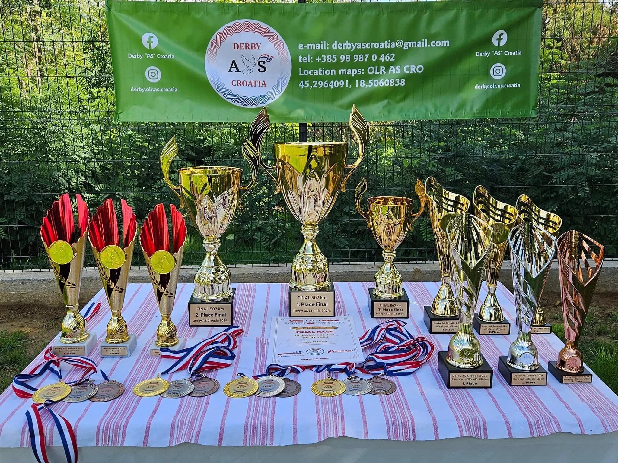 Pehari i medalje Derby AS kampa na stolu ispod transparenta